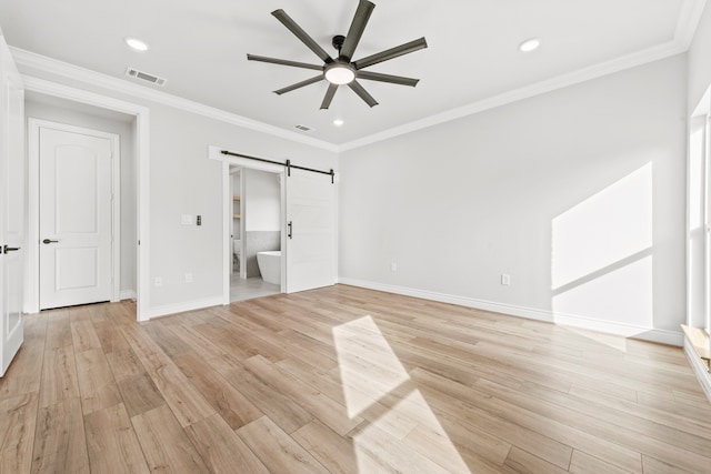 unfurnished bedroom featuring ceiling fan, light hardwood / wood-style floors, ensuite bath, and a barn door