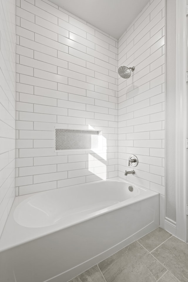 bathroom with tiled shower / bath and tile patterned flooring