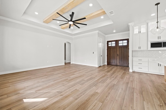 unfurnished living room with ornamental molding, light hardwood / wood-style floors, a tray ceiling, and ceiling fan