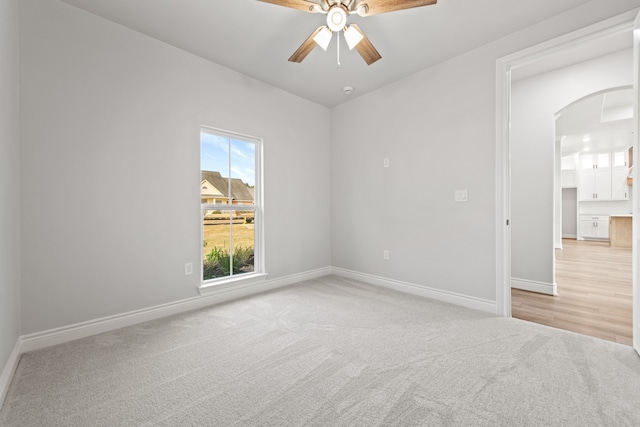 carpeted spare room featuring ceiling fan