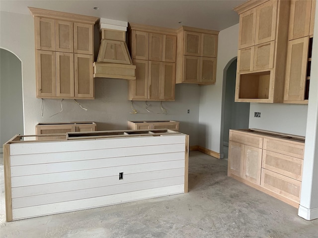 15408 Sandtrap Dr, Waller, TX 77484 - kitchen featuring arched walkways, unfinished concrete floors, premium range hood, a kitchen island, and light brown cabinetry