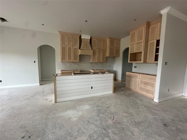 15408 Sandtrap Dr, Waller, TX 77484 - kitchen featuring arched walkways, custom exhaust hood, concrete floors, and light brown cabinets