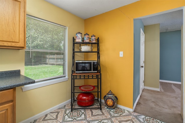 kitchen featuring light carpet and a textured ceiling