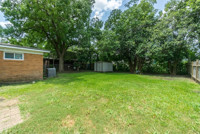 view of yard featuring a shed and central air condition unit