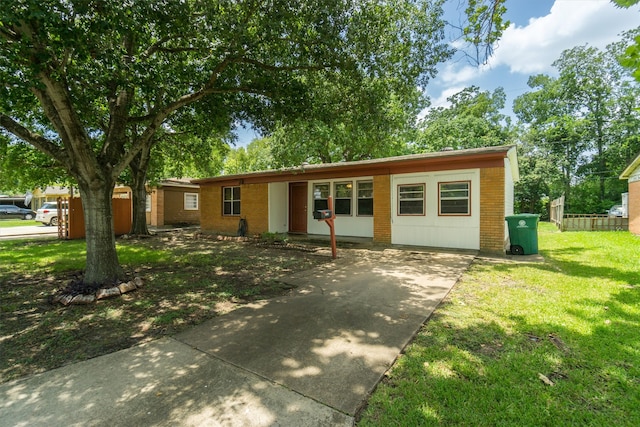 ranch-style home with a front yard and brick siding