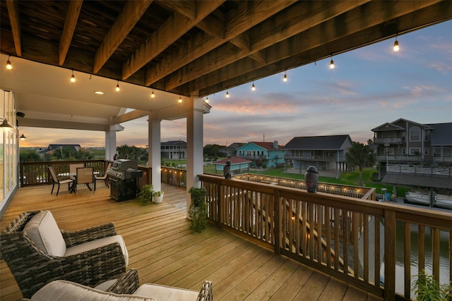 deck at dusk featuring a grill