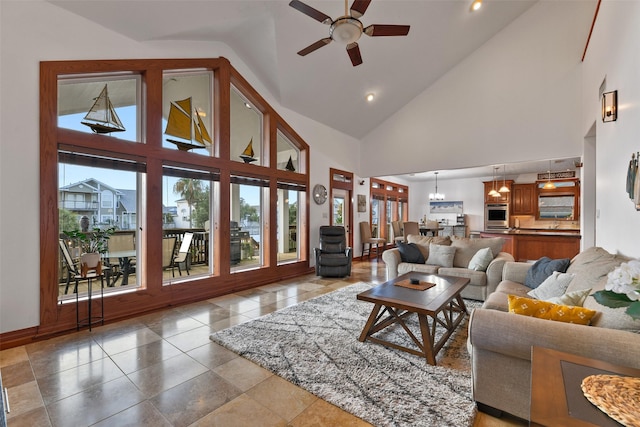 living room with ceiling fan with notable chandelier and high vaulted ceiling