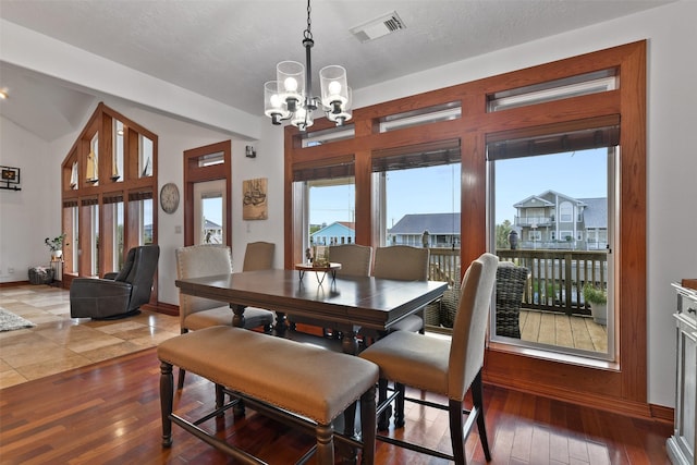 dining area with an inviting chandelier, a healthy amount of sunlight, and wood-type flooring