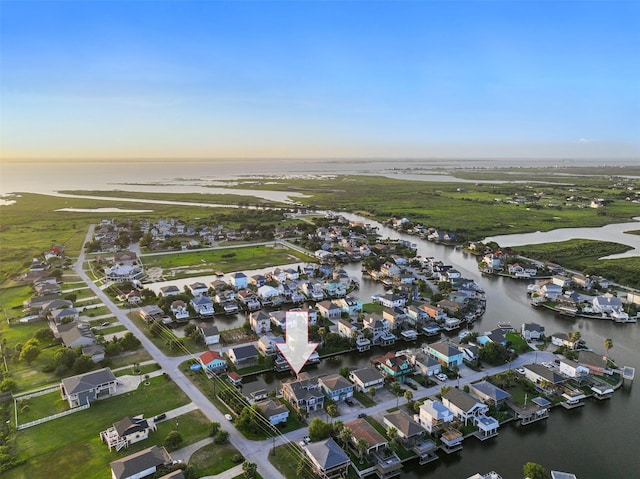 aerial view at dusk featuring a water view