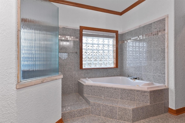 bathroom featuring crown molding and tiled tub