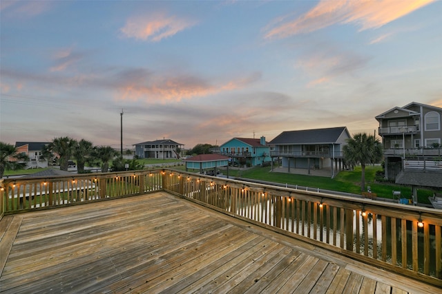 deck at dusk featuring a water view