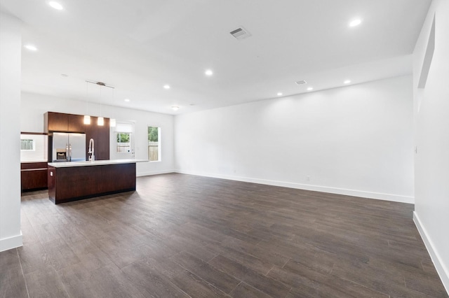 unfurnished living room with dark wood-type flooring and sink