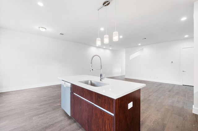 kitchen featuring a kitchen island with sink, sink, dishwasher, light hardwood / wood-style floors, and hanging light fixtures