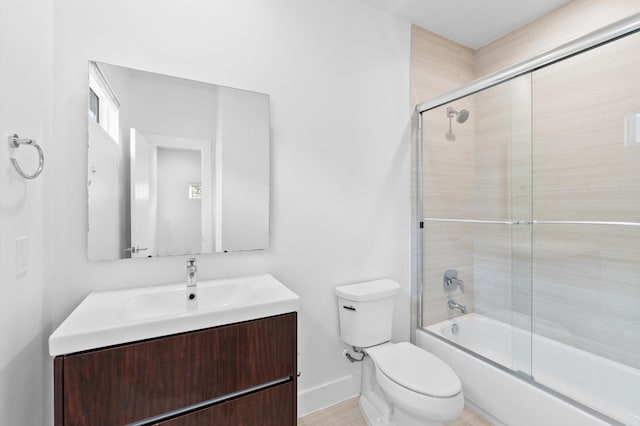 full bathroom featuring vanity, toilet, and shower / bath combination with glass door