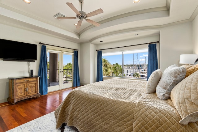 bedroom featuring access to outside, dark hardwood / wood-style flooring, multiple windows, and ceiling fan