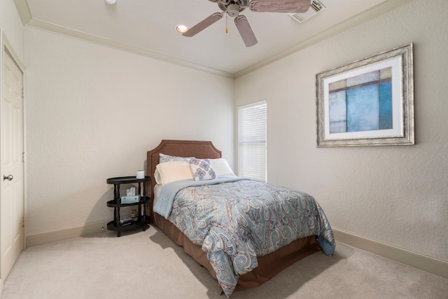 carpeted bedroom with ceiling fan and ornamental molding