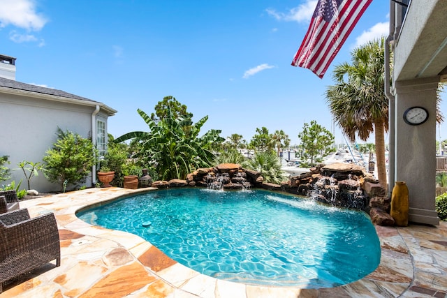 view of swimming pool featuring pool water feature and a patio area