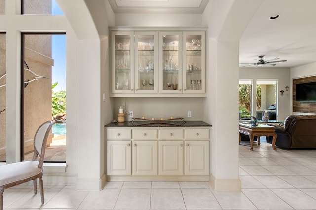 bar featuring cream cabinets, ceiling fan, and light tile patterned floors