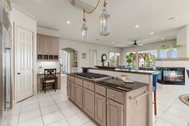 kitchen featuring a center island, appliances with stainless steel finishes, light tile patterned flooring, and tasteful backsplash