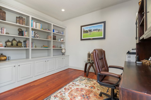 office area with dark wood-type flooring and crown molding