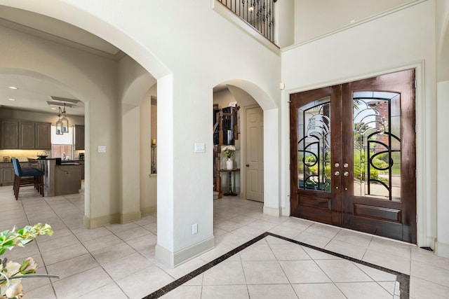 tiled entrance foyer featuring a healthy amount of sunlight and french doors