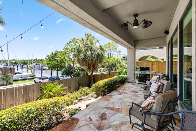 view of patio / terrace with grilling area and a water view