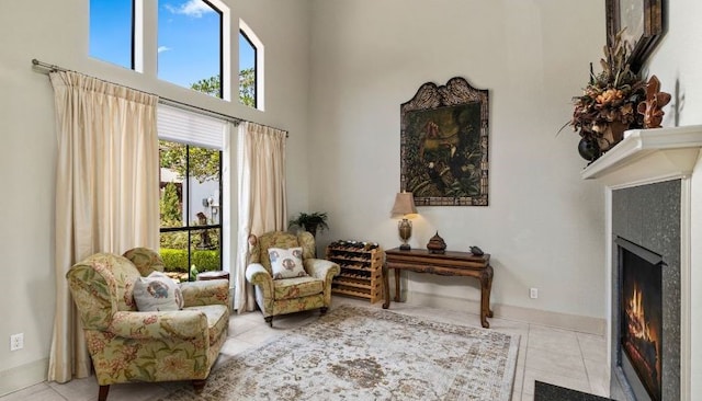 sitting room featuring a towering ceiling and light tile patterned floors