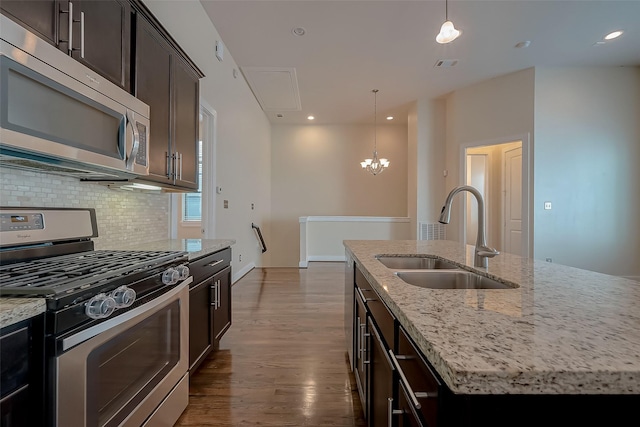 kitchen featuring pendant lighting, sink, an island with sink, and stainless steel appliances