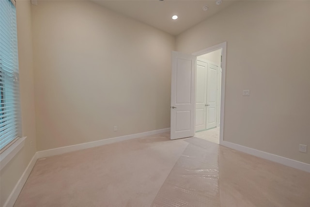 unfurnished room featuring light carpet