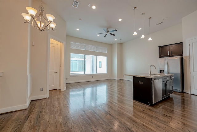 kitchen featuring a center island with sink, ceiling fan with notable chandelier, hanging light fixtures, and appliances with stainless steel finishes