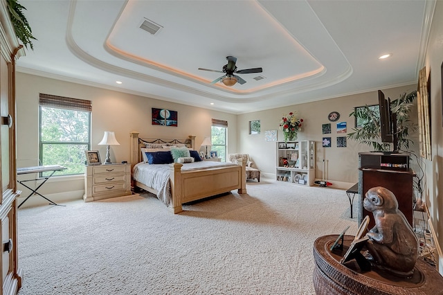 bedroom with ceiling fan, ornamental molding, carpet flooring, and a raised ceiling