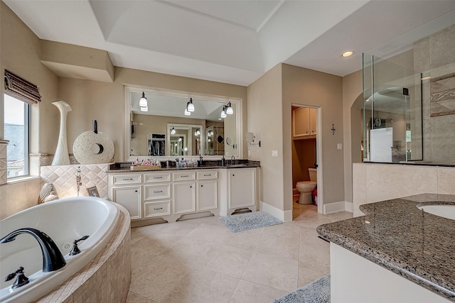 bathroom with tile patterned flooring, vanity, and plus walk in shower