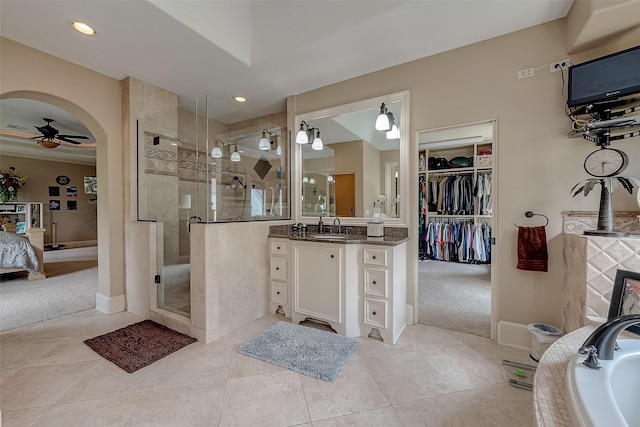 bathroom featuring tile patterned flooring, vanity, ceiling fan, and walk in shower