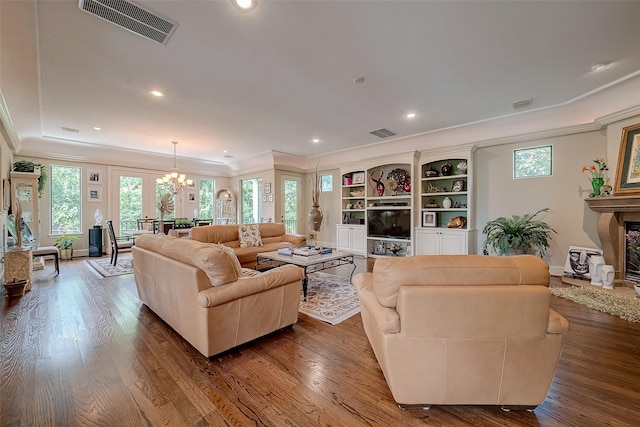 living room with crown molding, dark hardwood / wood-style flooring, and an inviting chandelier