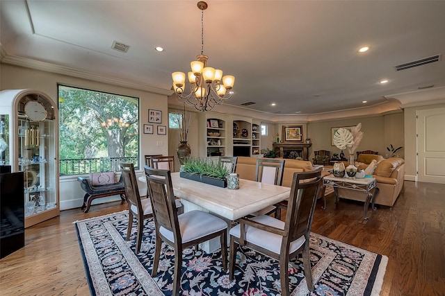 dining area featuring crown molding, a chandelier, and hardwood / wood-style floors