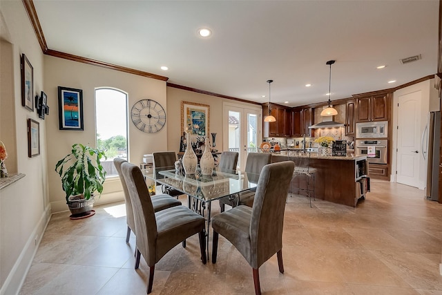 dining room featuring light tile patterned floors, ornamental molding, and french doors