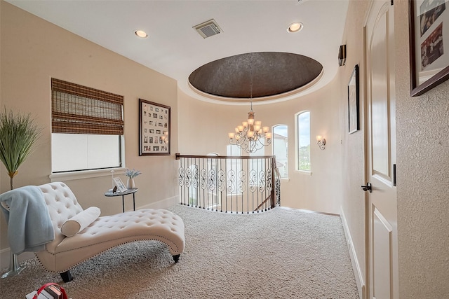 sitting room with a tray ceiling, carpet flooring, and a notable chandelier