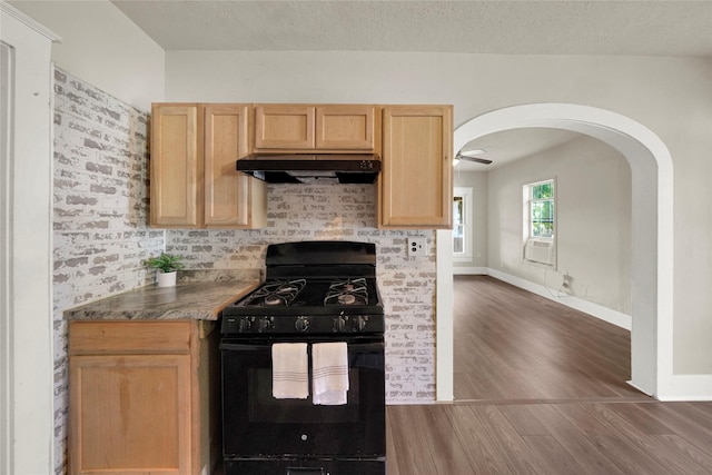 kitchen featuring light brown cabinetry, a textured ceiling, black range with gas stovetop, dark hardwood / wood-style floors, and range hood