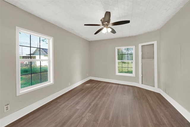 spare room with dark hardwood / wood-style flooring and ceiling fan