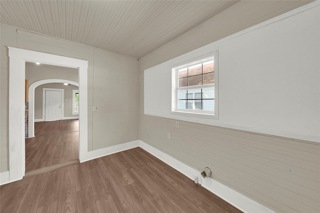 spare room with hardwood / wood-style flooring and wooden ceiling