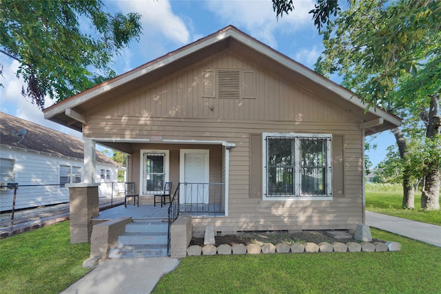 bungalow-style home with covered porch and a front yard