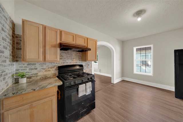 kitchen featuring dark hardwood / wood-style flooring, backsplash, black appliances, a textured ceiling, and light brown cabinetry