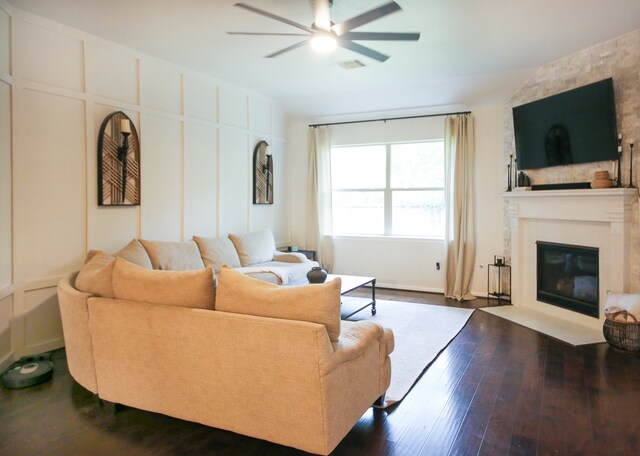 living room with ceiling fan, a fireplace, and dark hardwood / wood-style flooring