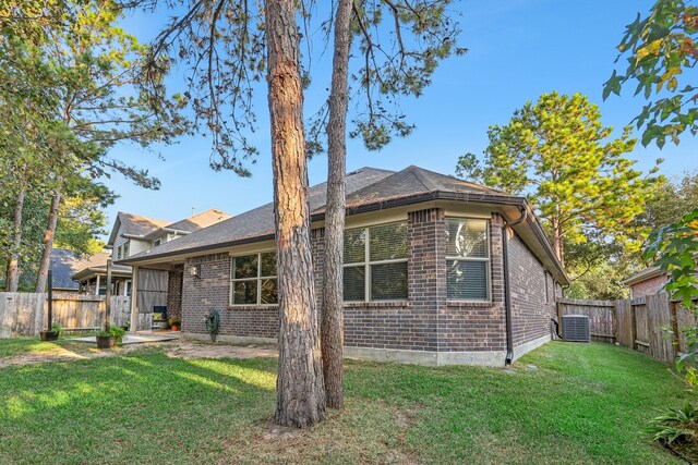 exterior space featuring a patio area, central AC unit, and a lawn