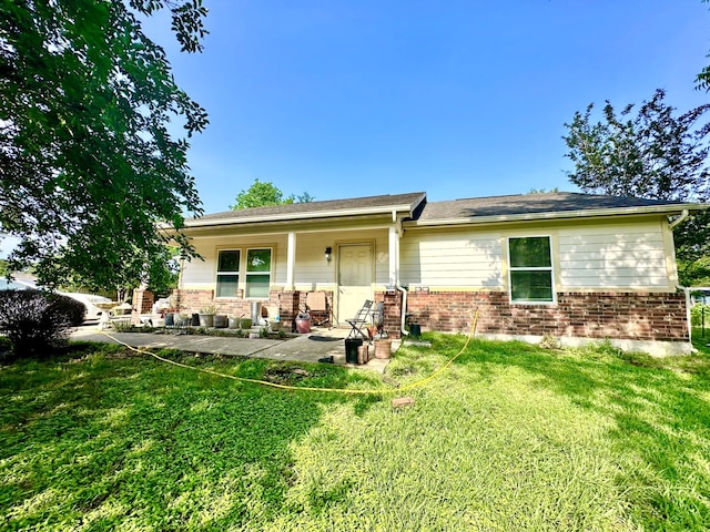 rear view of house featuring a yard and covered porch