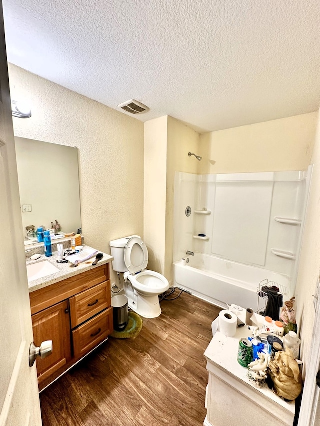 full bathroom featuring hardwood / wood-style floors, shower / tub combination, a textured ceiling, vanity, and toilet