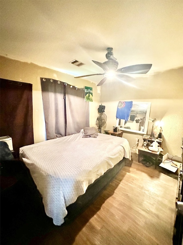 bedroom with ceiling fan and wood-type flooring