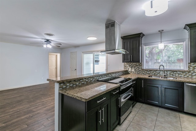 kitchen featuring sink, ceiling fan, decorative light fixtures, island range hood, and stainless steel appliances