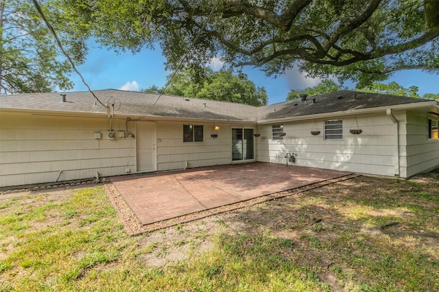 rear view of property featuring a lawn and a patio area