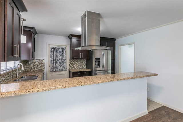 kitchen with stainless steel refrigerator with ice dispenser, sink, decorative backsplash, light stone countertops, and extractor fan